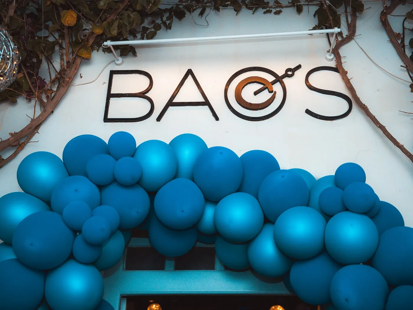 The BAO'S sign above a wall of blue balloons set up for a party