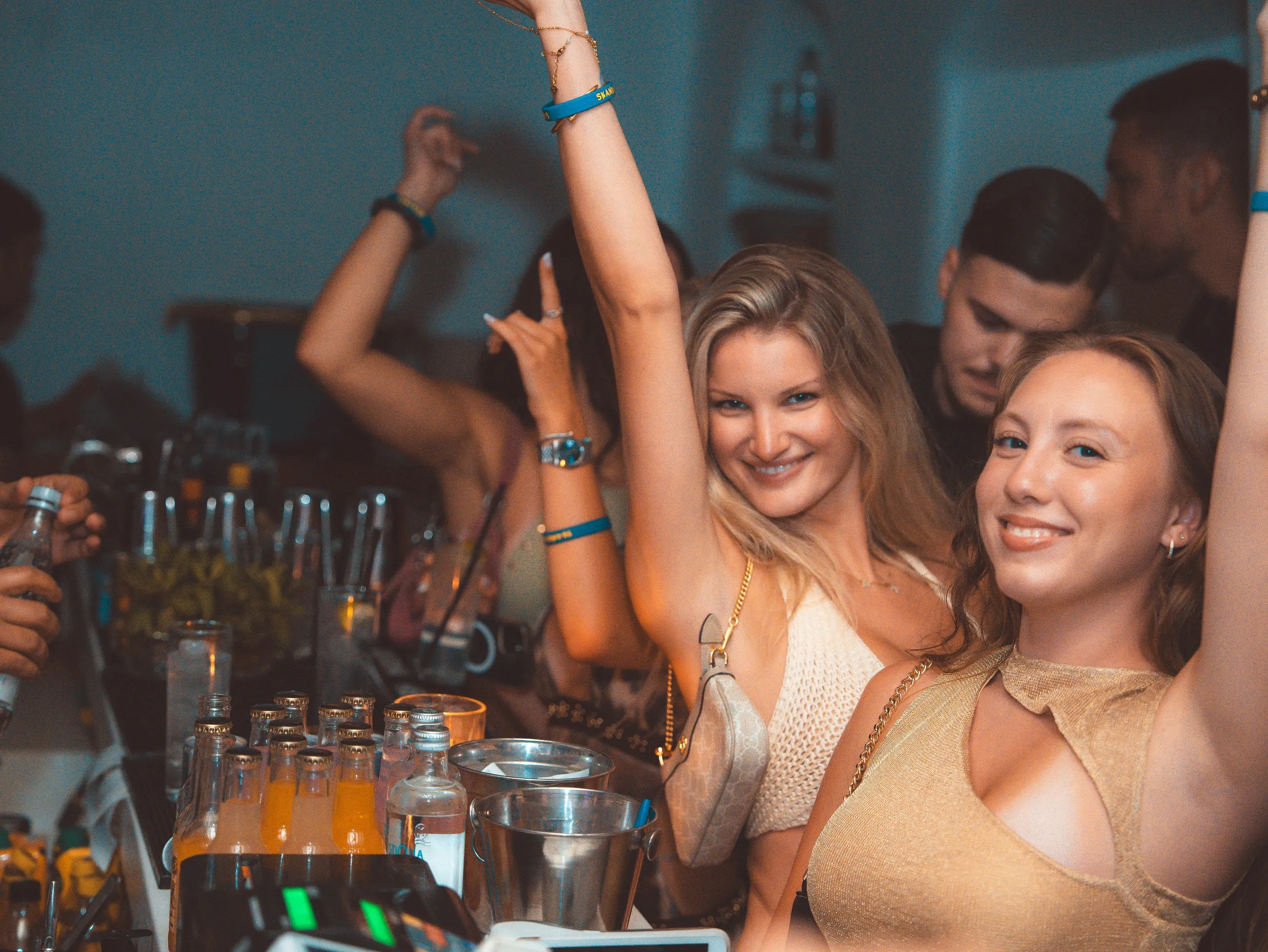 Two guests at the bar at BAO'S with their arms raised