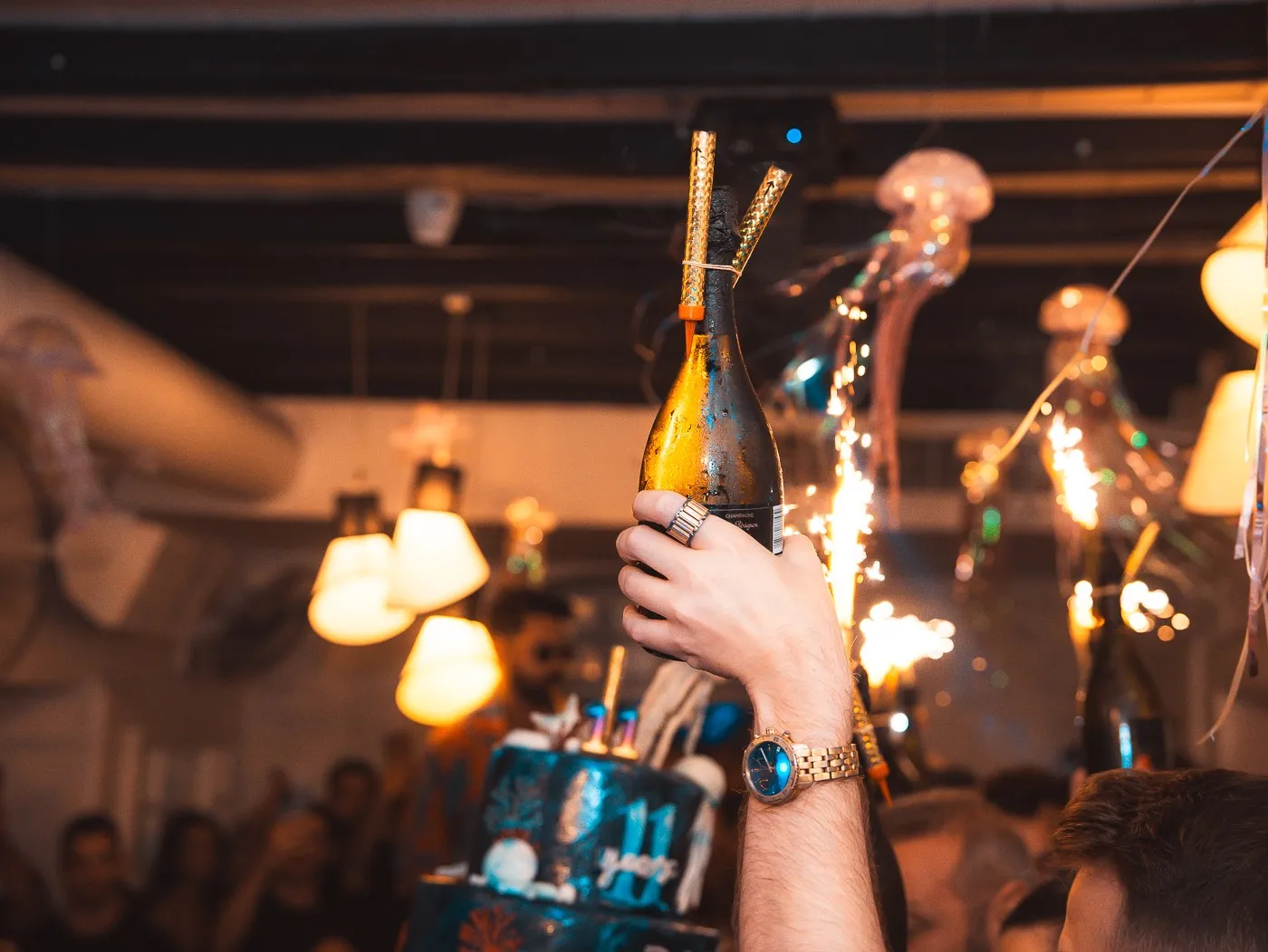 Bottles with sparklers carried above the crowd at BAO'S