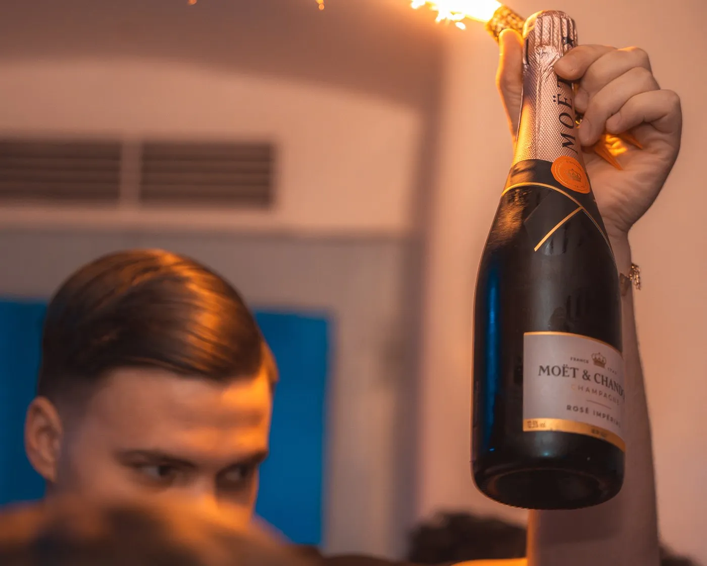 A champagne bottle raised above the crowd at BAO'S