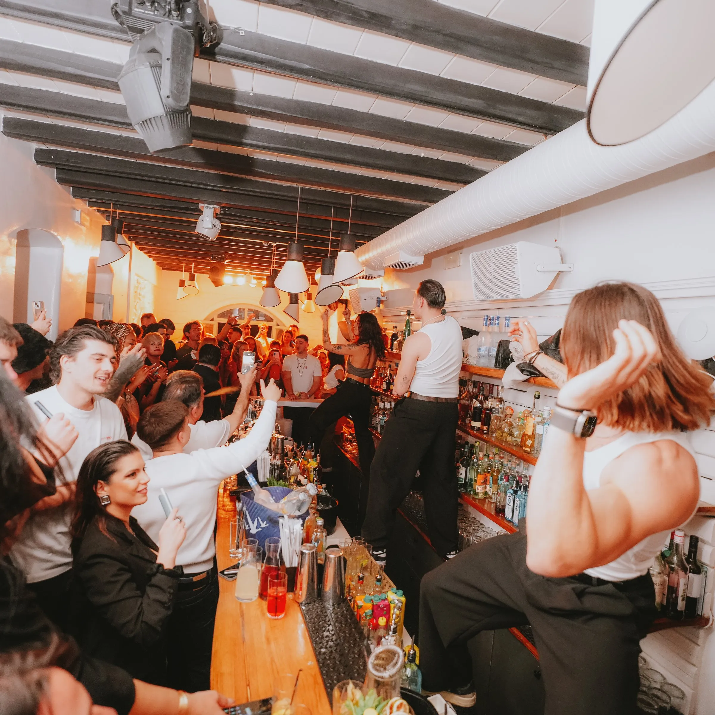 A packed night at BAO'S, glasses raised across the room