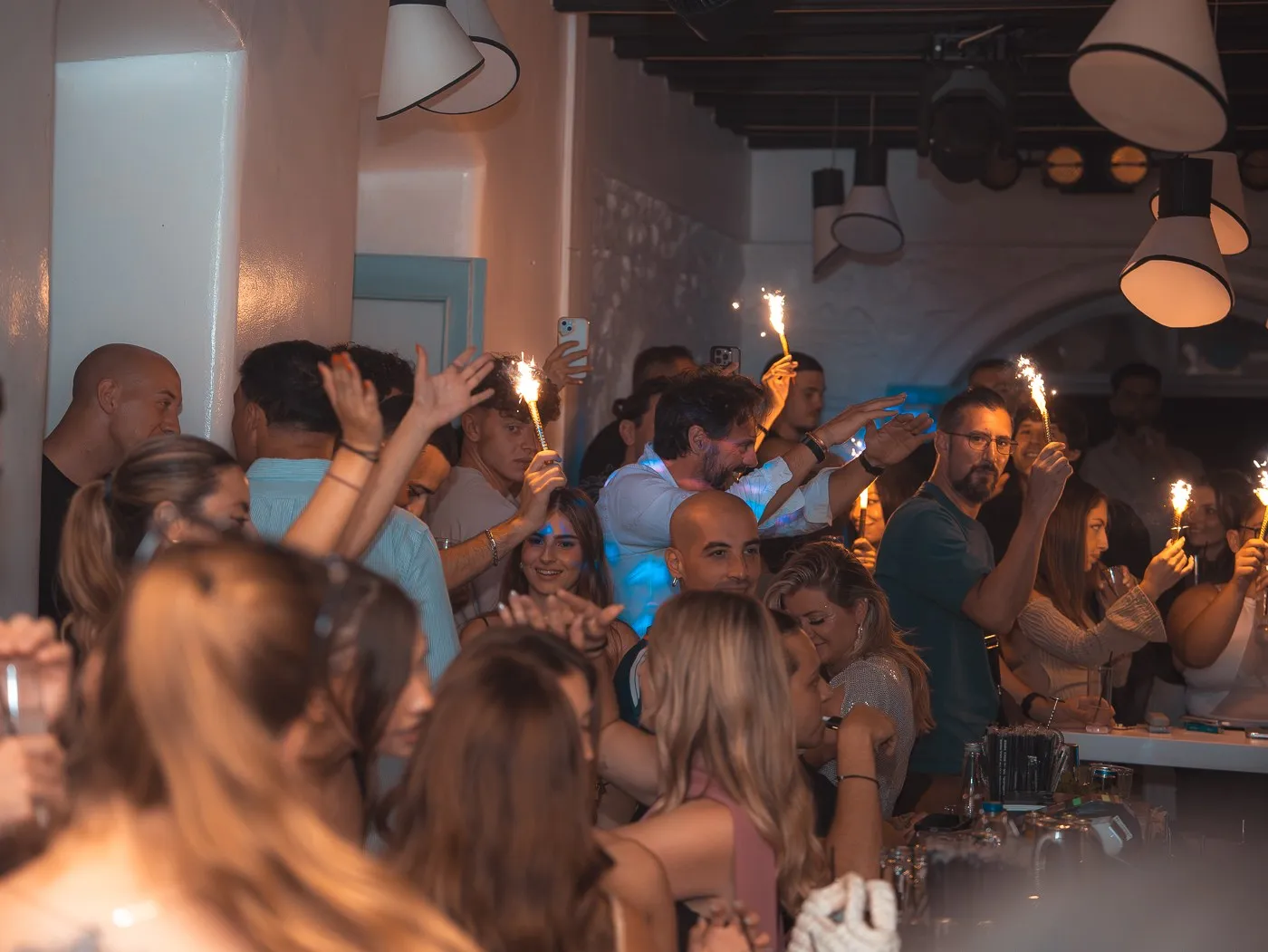 A room full of guests at BAO'S with sparklers held up above the crowd