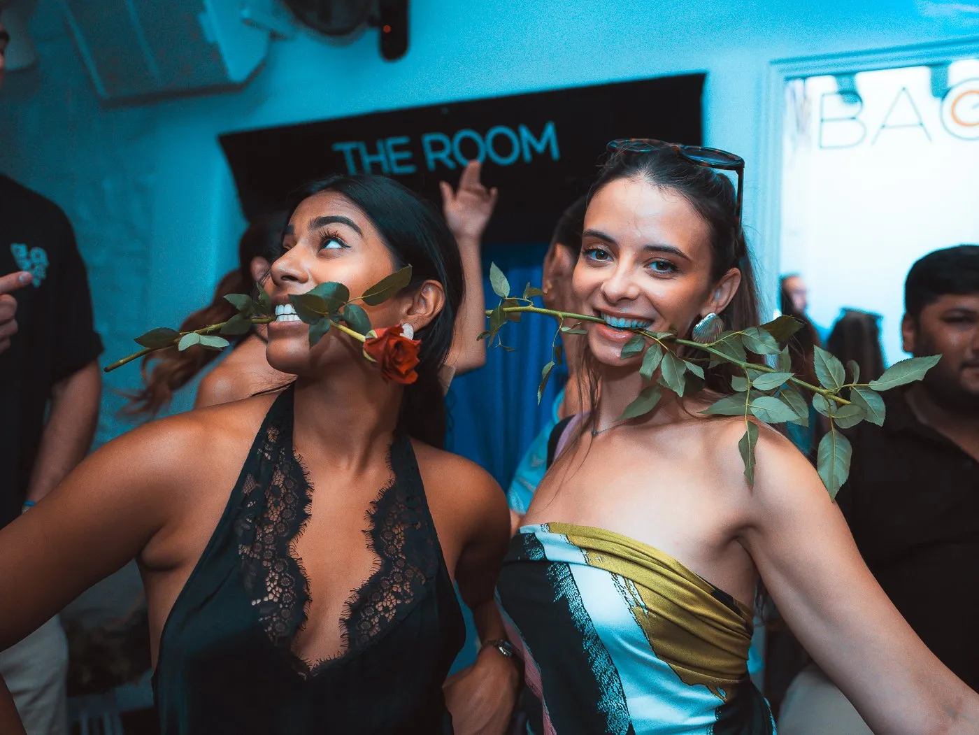 Guests beside the neon sign marking The Room