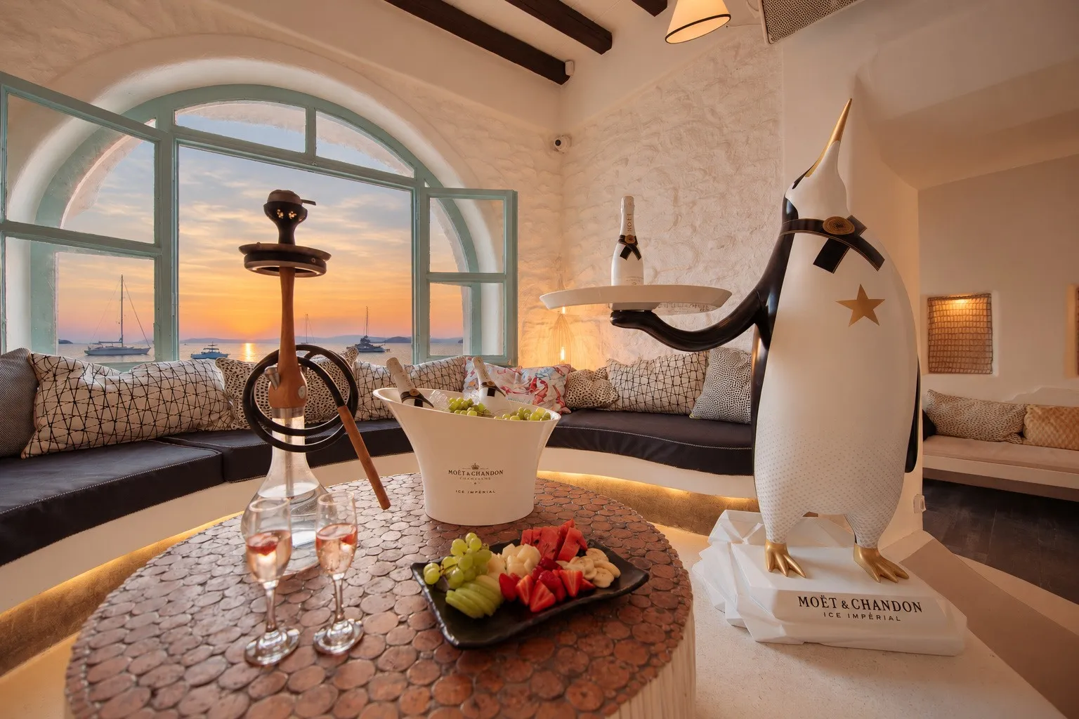 A shisha and a bowl of grapes on the pebble-topped table at BAO'S, warm sunset light across the room