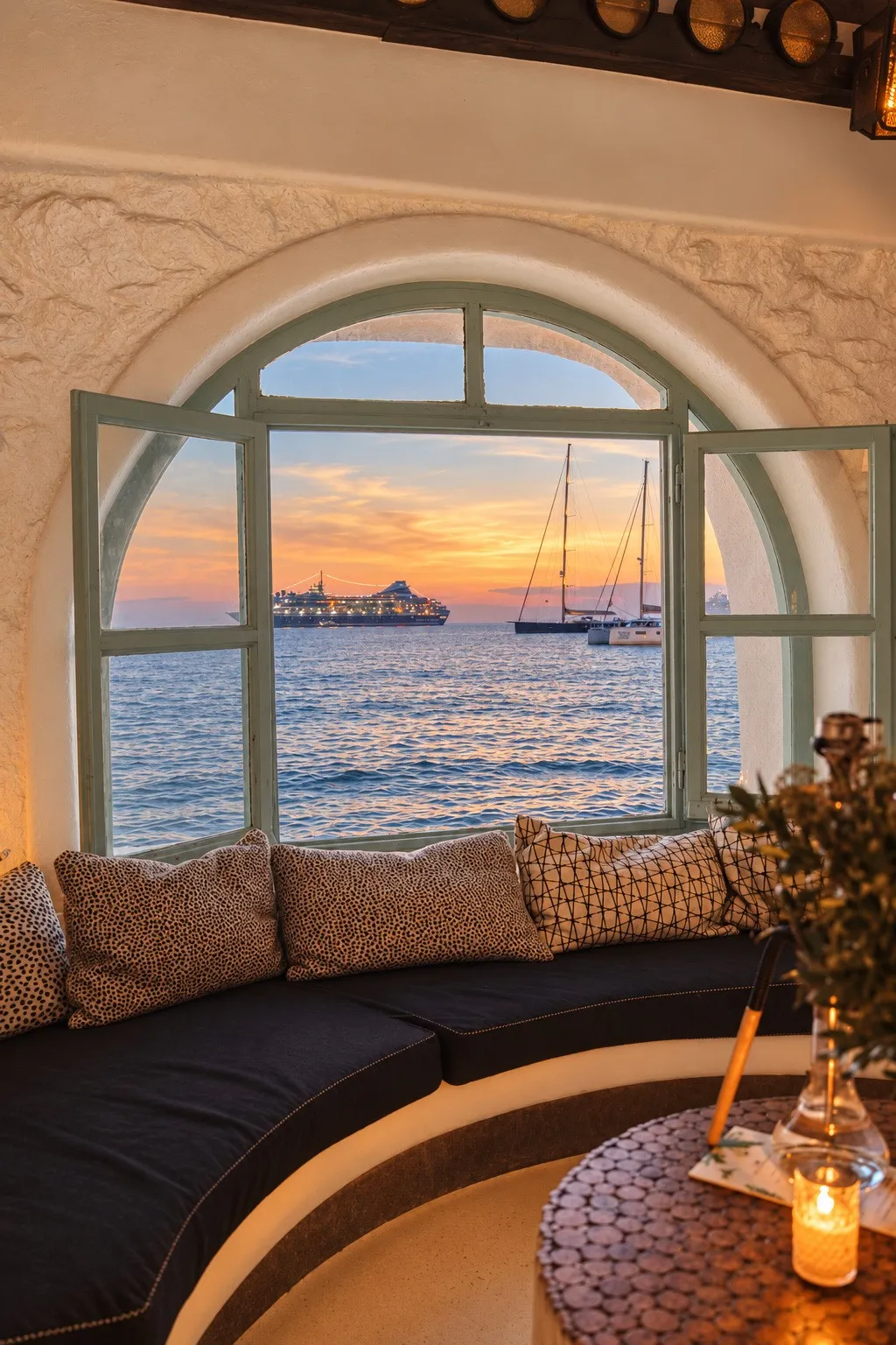 A shisha beside the arched window at BAO'S, the sun low over the boats in the bay