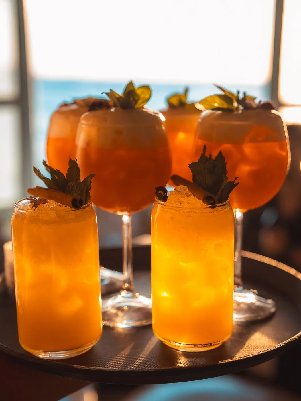Ein BAO'S Cocktail auf der Brüstung unter einem Makramee-Schirm, dahinter die Häuser von Klein-Venedig